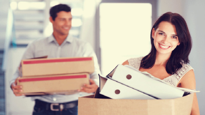 happy young couple packing things into boxes