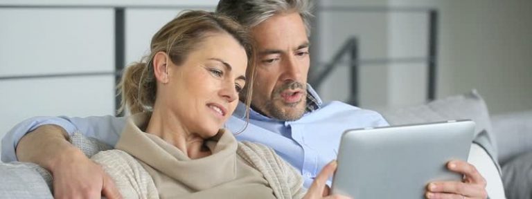 A couple is searching for something on a tablet