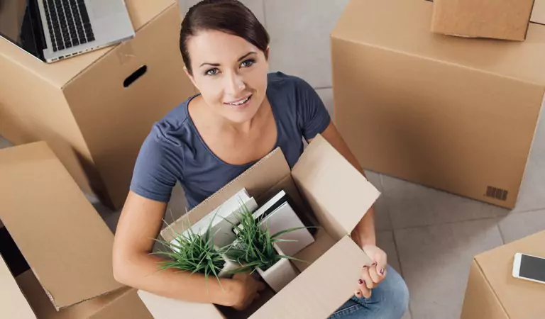 woman packing plants into a cardboard box