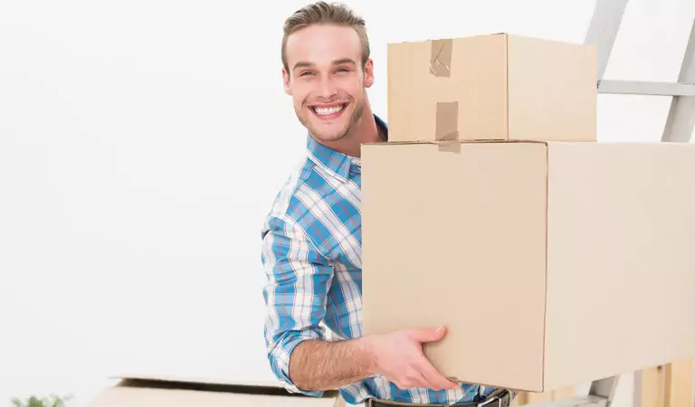 Young man wearing check shirt holding a couple of cardboard boxes