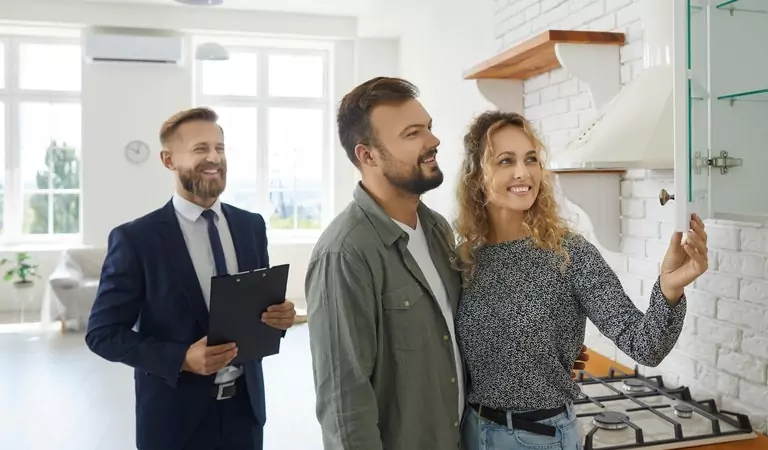 couple inspectnig a property and the property manager at the backside