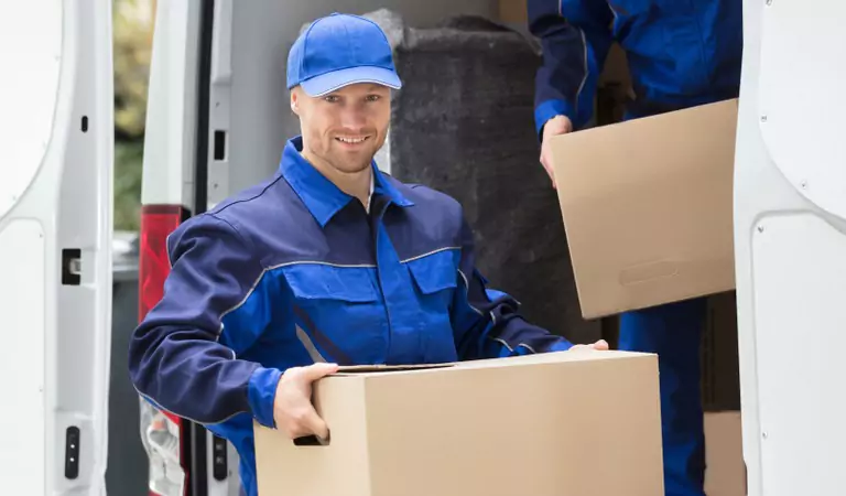 Well dressed professional with a cardboard box and a van at the back