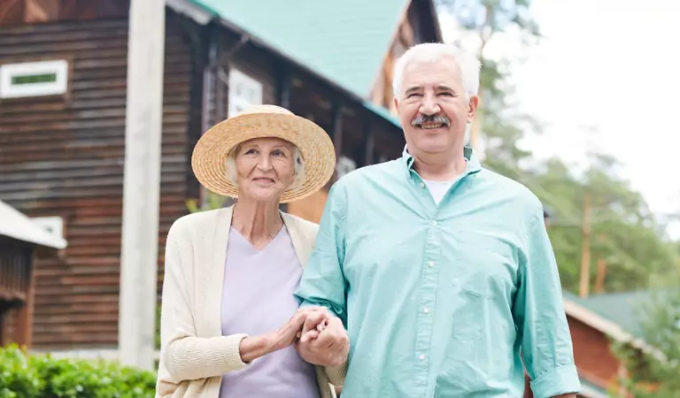old age couple outside of their house