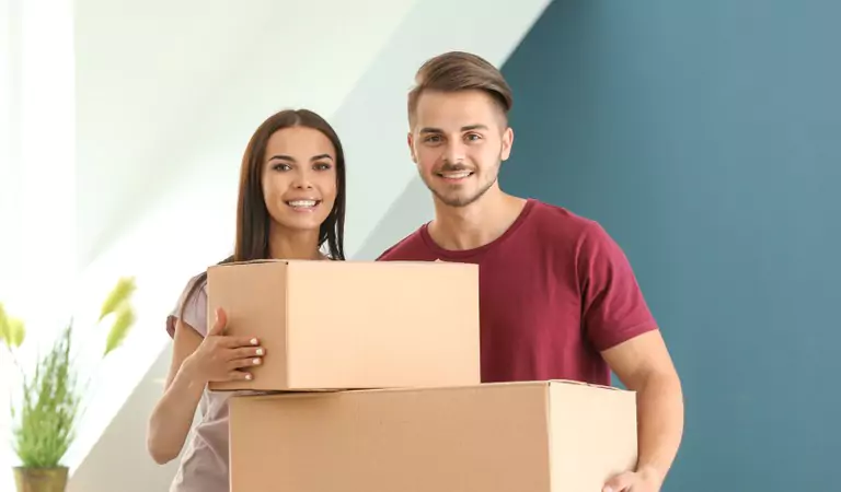 couple holding cardboard boxes in hands safely
