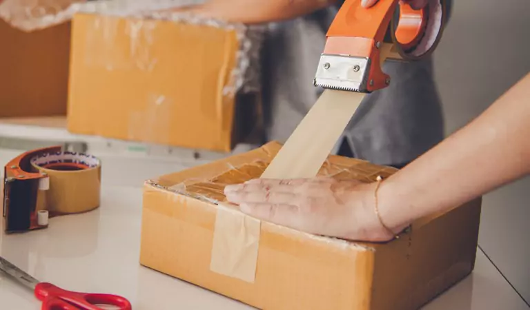 cropped picture of a person packing up a box