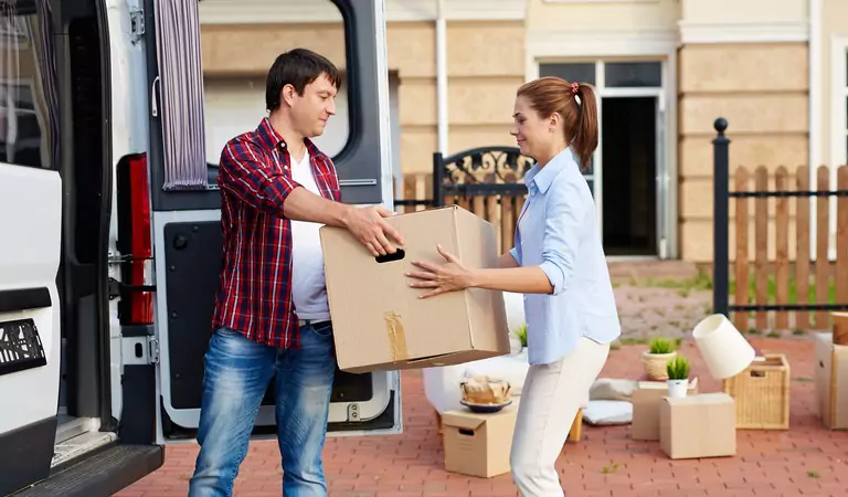 couple loading cardboard boxes into a truck