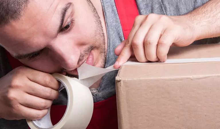 young man packing a cardboard box