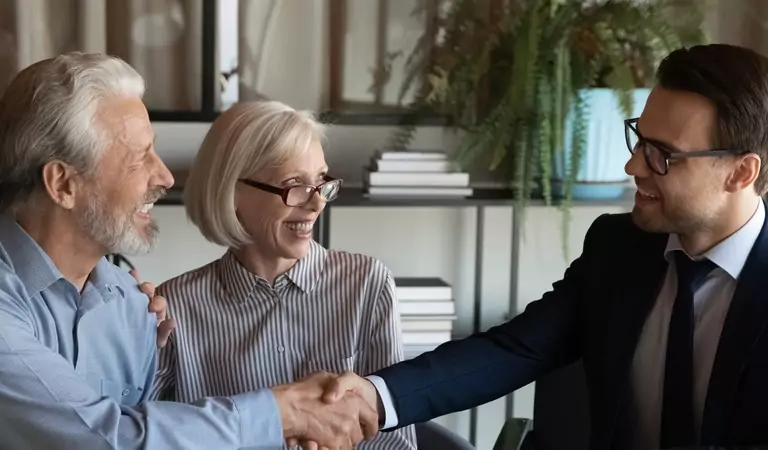 old age couple and a young profesional making a deal