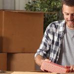 young man packing something in a cardboard box