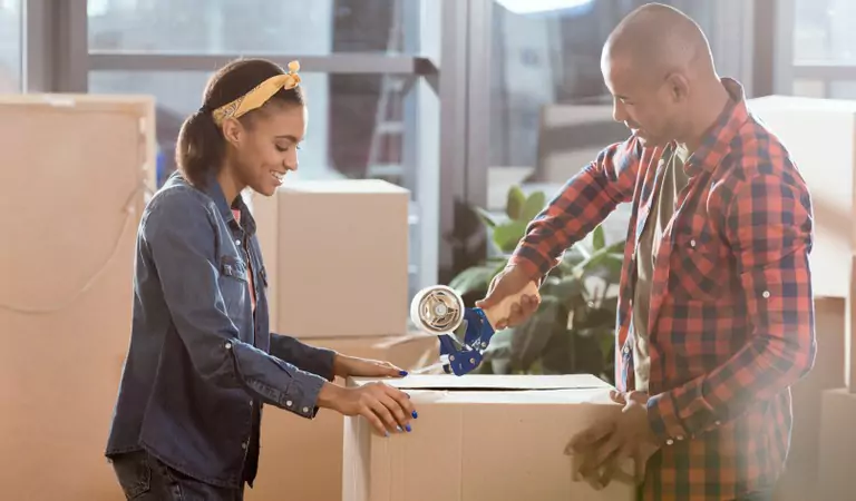 couple packing up a cardboard box