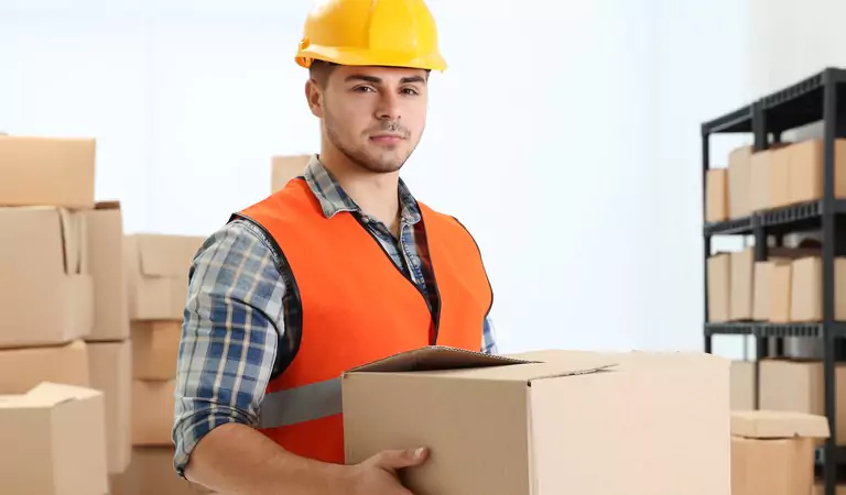 young professional with a box inside of a storage unit