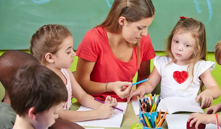 teacher giving lesson to the young students