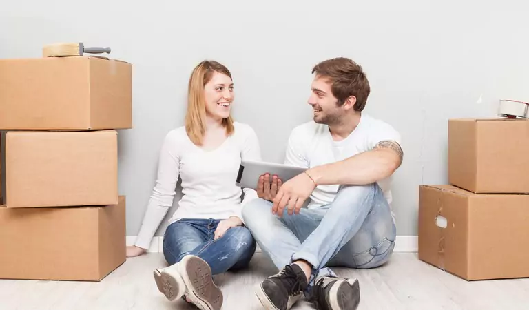 couple sitting on the floor with a tablet