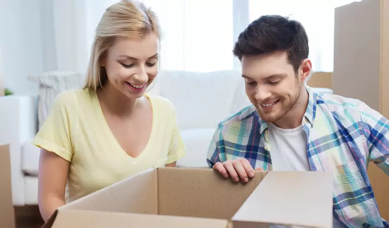 couple with a cardboard box preparing to pack something
