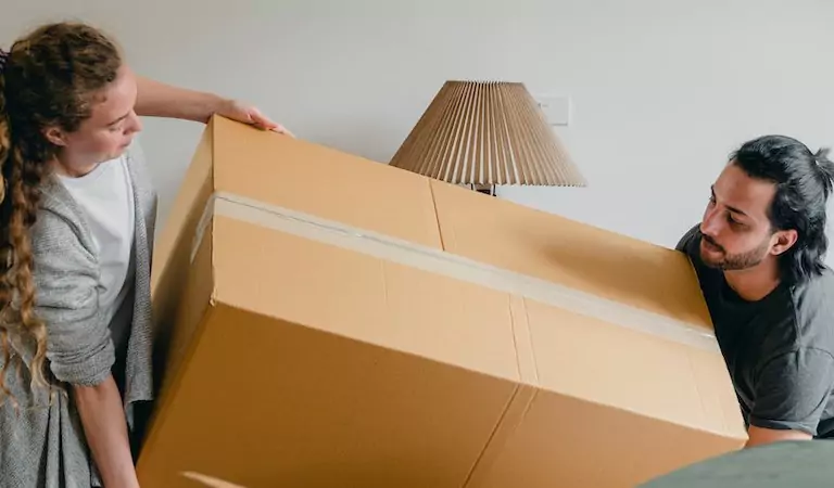 couple trying to lift a heavy box